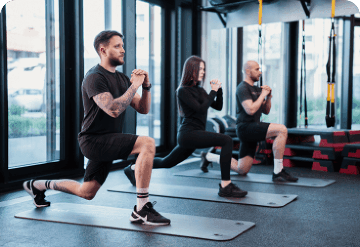 Three people dressed in black working out at the gym.
