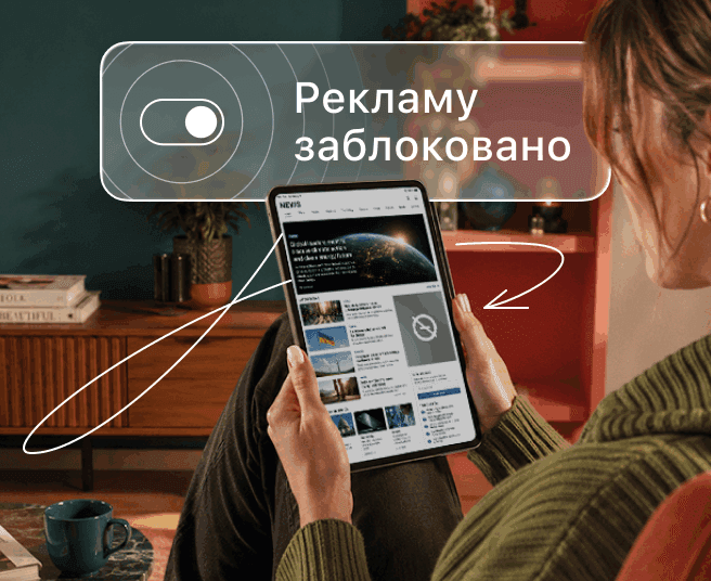 Людина тримає планшет із накладенням, на якому відображається перемикач і текст «Рекламу заблоковано».
