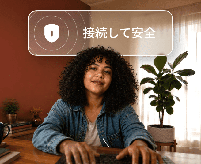 デスクのノートパソコンでタイピングしている髪にパーマがかかった人物。その上に「Connected and safe（安全に接続されました）」という吹き出しがある。