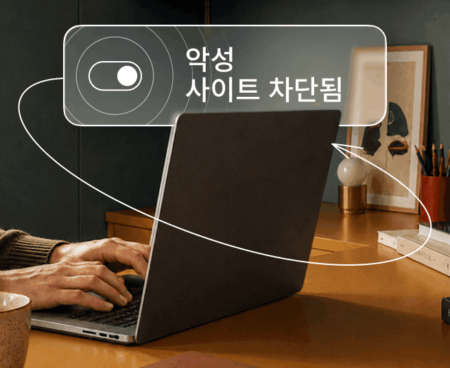 노트북으로 타이핑하고 있는 사람과 디지털 오버레이에 토글 스위치와 '악성 사이트 차단됨' 텍스트가 표시된 모습.