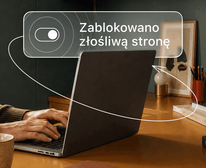 Osoba pisze na laptopie, a na cyfrowej nakładce wyświetla się przełącznik i tekst „Zablokowano złośliwą stronę”.