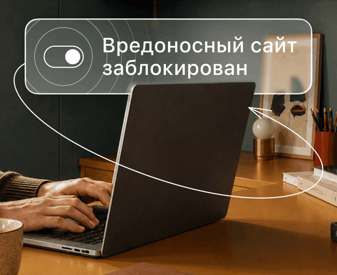 Человек печатает на ноутбуке, а на цифровом наложении отображается переключатель и текст «Вредоносный сайт заблокирован».