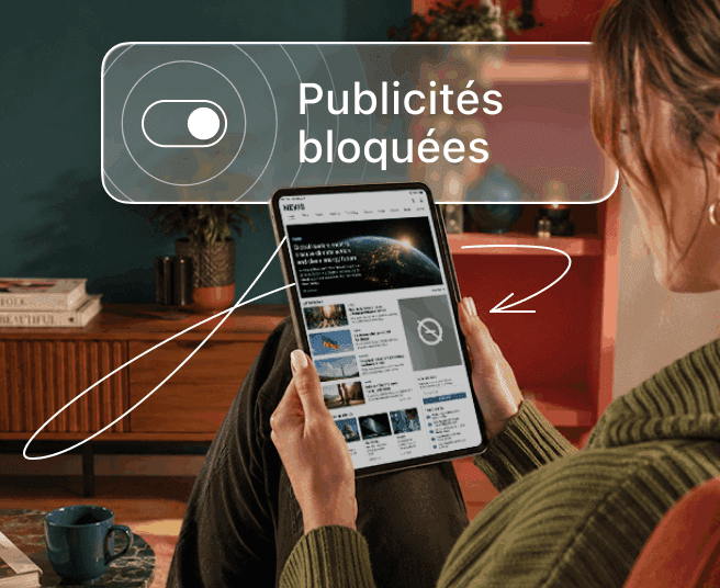 Une personne tenant une tablette sur laquelle est affichée une fenêtre contextuelle avec un bouton bascule et le texte « Publicités bloquées ».