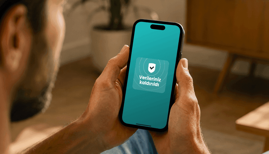 Kalkan simgesi ve Verileriniz kaldırıldı metni bulunan bir bildirimi gösteren akıllı telefonu tutan kişi.