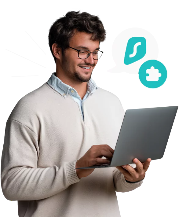 A man with wavy hair and glasses holding a laptop, next to a speech bubble containing the Surfshark logo and a puzzle piece.