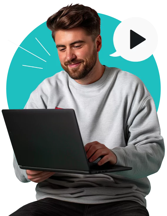 A smiling, bearded young man in a gray sweatshirt using a laptop with a play icon in a speech bubble near his face.