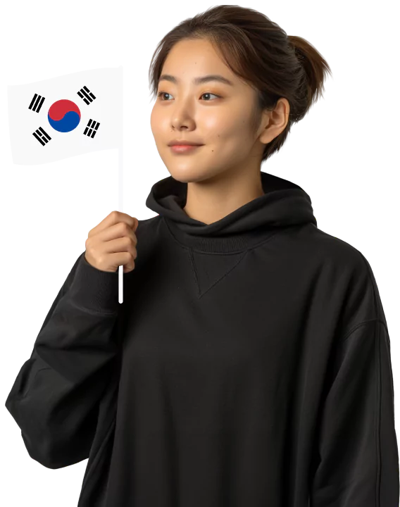 Eine junge Frau in einem schwarzen Kapuzenpullover mit einer kleinen Südkorea-Flagge in der Hand steht vor einem blaugrün und schwarzen Hintergrund.