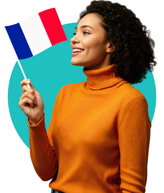 A smiling woman in an orange turtleneck holding a French flag.