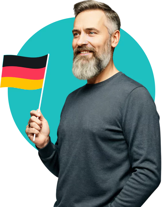 Ein bärtiger, lächelnder Mann mit grauem Haar hält eine deutsche Flagge.