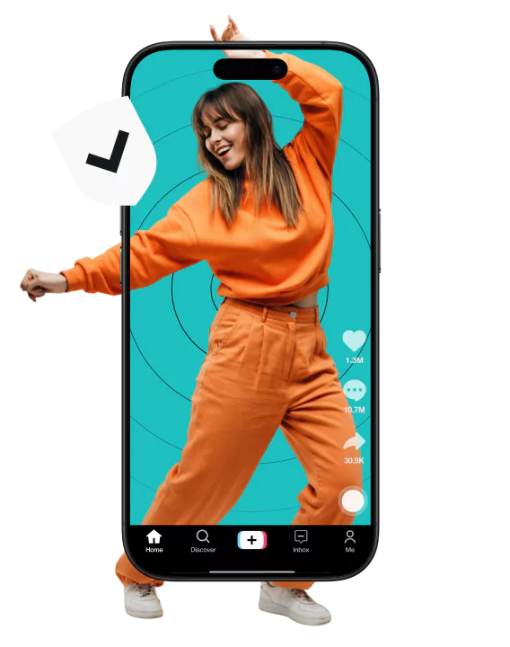 A woman dancing in an orange sweatsuit with her body partially in a smartphone screen that displays a social media interface.