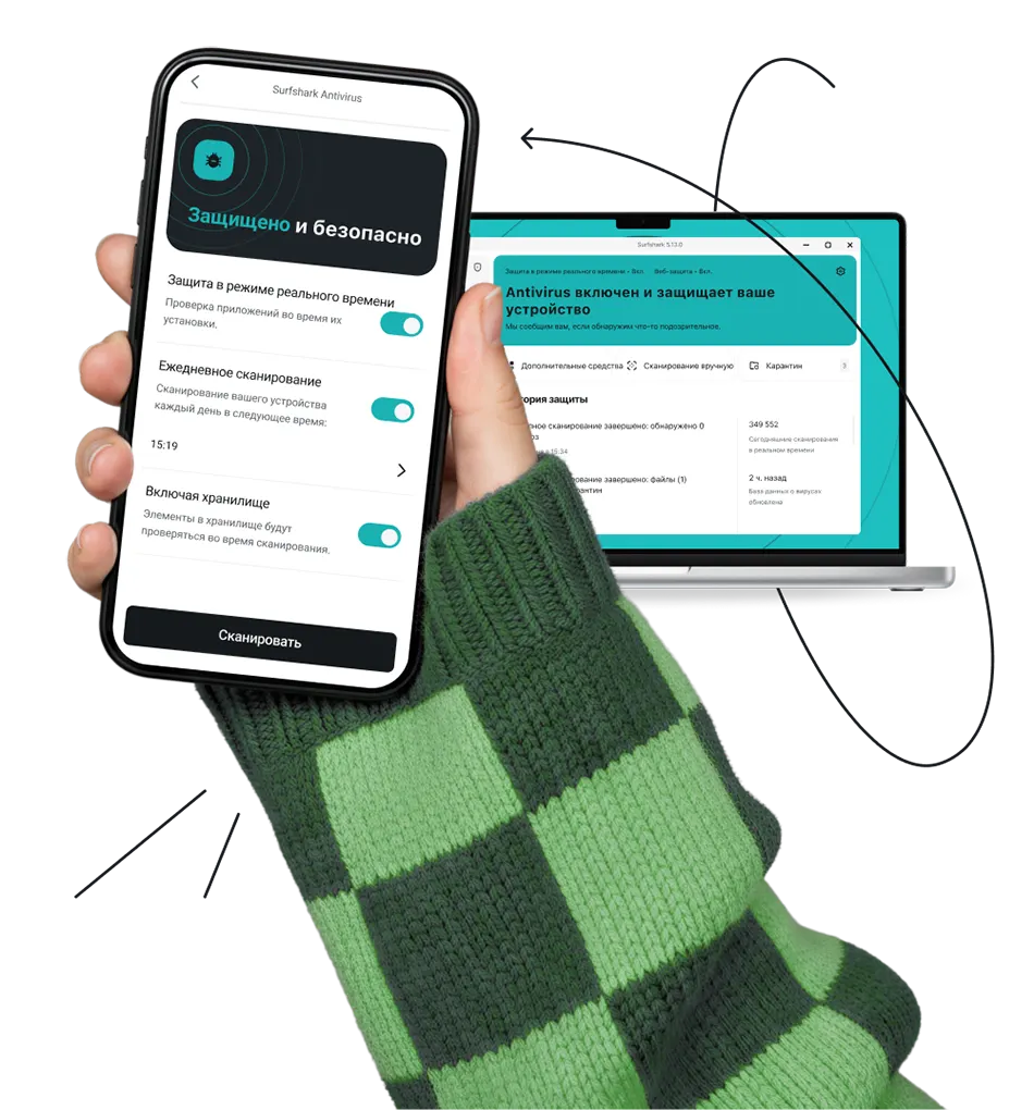 Рука, держащая смартфон, отображающий интерфейс антивируса, расположенный перед ноутбуком, с петляющей вокруг закорючкой.
